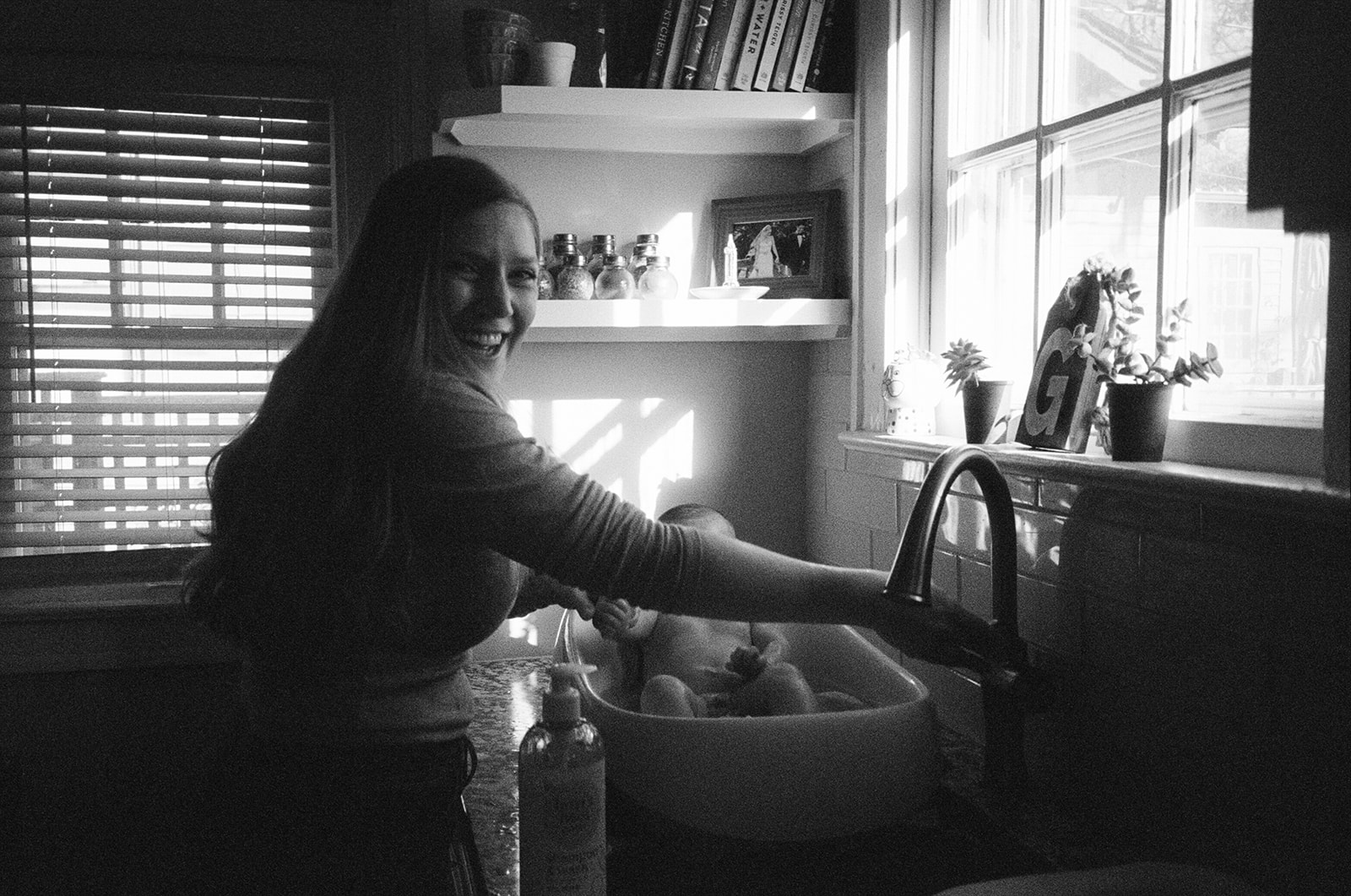 woman bathes her baby in sink